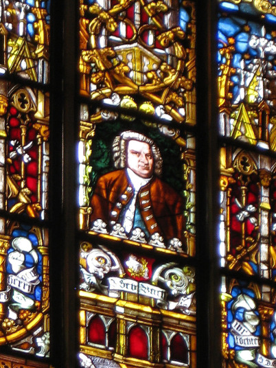 In 9 Feldern eines gewaltig bunten Kirchenfensters schaut man von der Innenseite im mittleren Quadrat auf ein Bildnis von Johann Sebastian Bach.