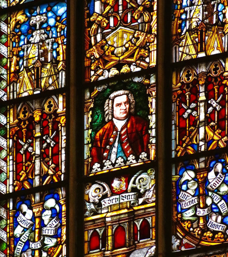 In 9 Feldern eines gewaltig bunten Kirchenfensters schaut man von der Innenseite im mittleren Quadrat auf ein Bildnis von Johann Sebastian Bach.
