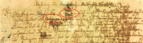 Ein uraltes handschriftliches Dokument ist kaum lesbar und hat auch starke Flecken. Zwei Worte sind mit einem roten Oval gekennzeichnet.