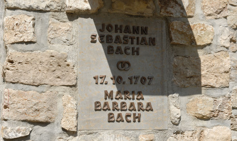 Ganz groß sieht man eine Tafel vor einer Mauer. Auf Ihr stehen die Namen Johann Sebastian Bach und Maria Barbara Bach sowie das Datum der Hochzeit, der 17.10.1707.