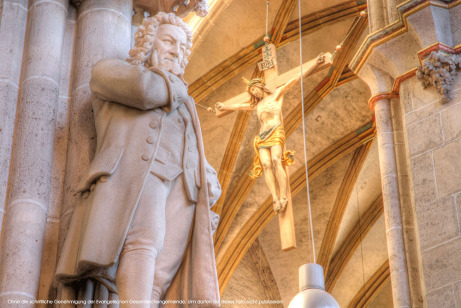 Johann-Sebastia- Bach-Denkmal im Ulmer Münster, im Hintergrund Christus am Kreuz