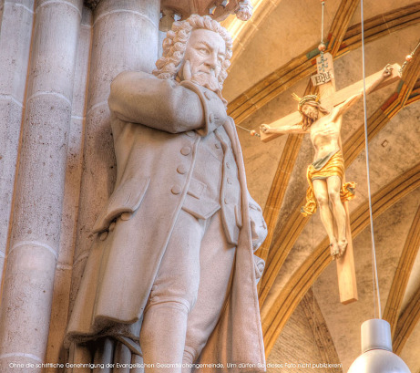 Johann-Sebastia- Bach-Denkmal im Ulmer Münster, im Hintergrund Christus am Kreuz
